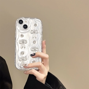 Detail of silver wavy iPhone case featuring 3D metallic bows and small heart accents