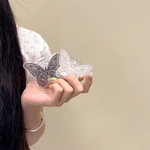 Detail view of acrylic butterfly phone grip with black and white lace patterns