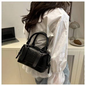 Detail of black Boston handbag with ENJOY LIFE embossing and adjustable strap