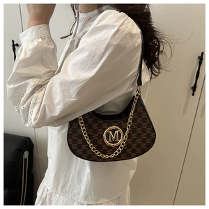 Detail of dark brown crescent bag with M-pattern jacquard and golden chain strap