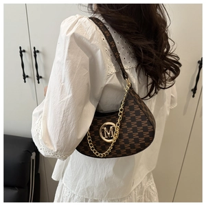 Close-up of vintage brown underarm bag with M-pattern print and gold chain detail