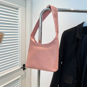 Retro pink woven hobo bucket bag with a wide shoulder strap in a minimalist style