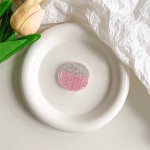 Détail du support téléphone pailleté avec sequins roses et argentés sur un plateau