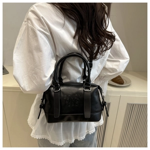 Vue mannequin d'un sac Boston en cuir PU mat noir avec bandoulière et détails embossés