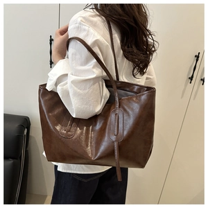 Close-up of brown PU leather tote bag with vintage texture and vertical strip detail