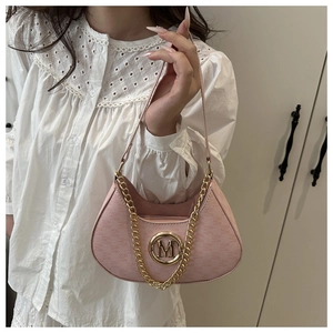 Detail of pink faux leather underarm bag with golden M logo and decorative chain