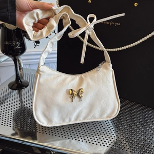 White ruched underarm bag with metal butterfly and bow-tie strap detail