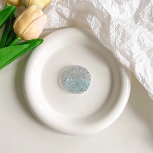 Vue détaillée d'un support de téléphone à paillettes bleues et argentées sur un plat