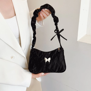 Black pleated underarm bag with silver butterfly ornament and decorative bow strap