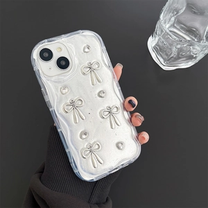 Close-up of wavy transparent iPhone case with silver bow, heart rhinestones and glitter