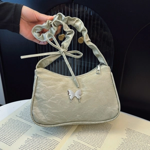 Pale green pleated shoulder bag with silver butterfly charm and scrunchie strap