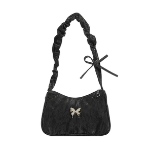 Minimalist black pleated shoulder bag with metallic butterfly and ruched handle detail