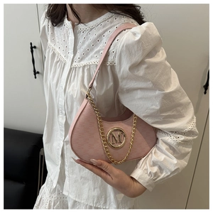 Detailed view of pink leather bag featuring a gold M-letter logo and elegant chain strap