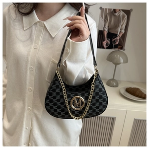 Detail of black crescent shoulder bag with M letter monogram and gold chain strap