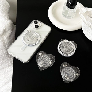 Glitter heart phone socket with silver bow on transparent case over black desk