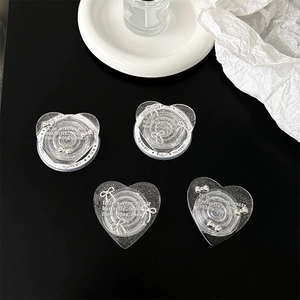 Macro shot of glittery heart phone grips with silver bows and Gift For You text