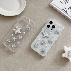 Transparent iPhone case featuring silver glitter stars and white pearls on grey surface