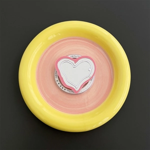Close-up of heart-shaped MagSafe phone grip with a pink border on its gift packaging