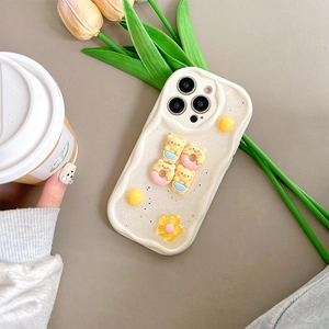 Detail of cream wavy iPhone case with glitter finish, 3D bear and donut accessories