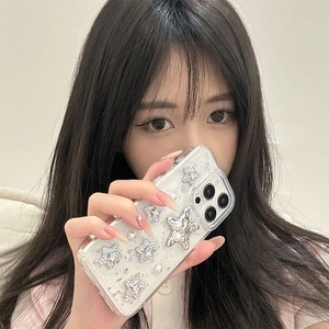 Close-up of clear iPhone case with silver 3D stars and pearls held by a model