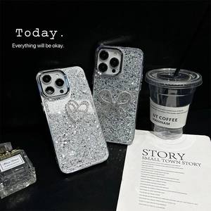 Sparkly glitter iPhone case with pearl bow and heart design on dark background
