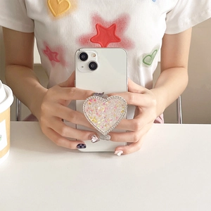 Sparkling heart-shaped phone grip with silver rhinestones and glitter held by hand