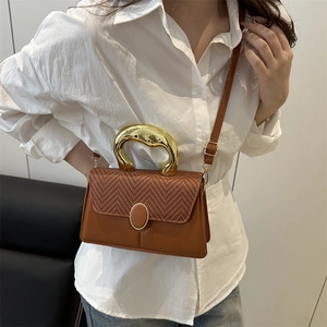 Brown leather crossbody bag with woven flap and sculptural gold metal handle for women