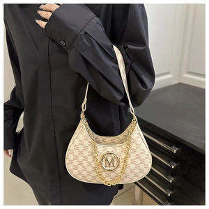 Detail of beige hobo bag with M-letter pattern, golden logo and chunky metal chain strap
