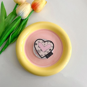 Detail of pink heart-shaped MagSafe phone grip with rose print on a ceramic tray