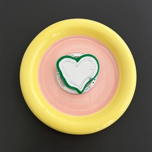 Macro detail of Magsafe phone grip with heart-shaped makeup mirror on yellow acrylic base