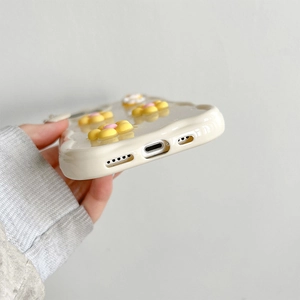 Detail view of precise bottom cutouts and 3D floral decor on creamy white phone case