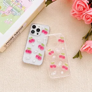 Clear iPhone case with cherry, pearl and bow decorations on a beige texture background