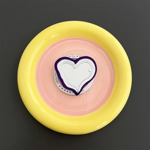 Macro shot of purple heart-shaped MagSafe phone grip with white center on gift card