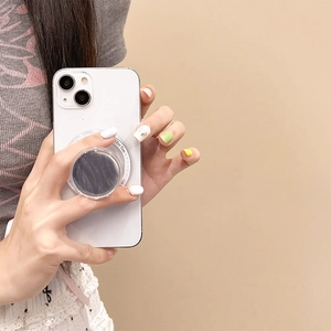 Detail of grey marble pattern phone grip with Gift For You text on a white smartphone