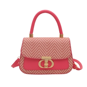 Sac à main rose avec texture tissée, fermoir doré et bandoulière amovible en vue frontale
