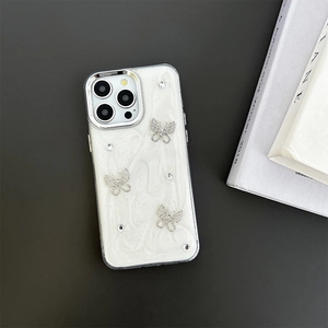 Macro detail of luxury pearl white iPhone case with sparkling rhinestone butterfly accents