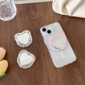Macro shot of glitter heart magnetic phone socket with mirror on dark wood background