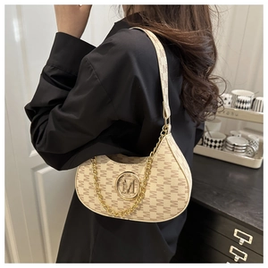 Close-up of beige underarm bag with M letter prints and gold chain detail