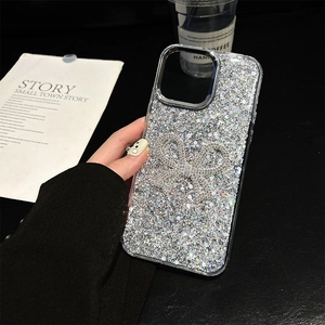 Sparkling glitter phone case with large rhinestone bow decoration held by hand