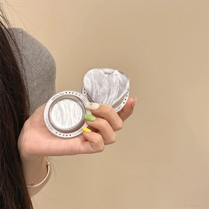 Close-up of glitter highlighter with silver ripples in heart and round cases