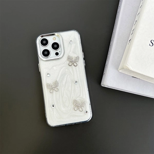 Macro shot of white iPhone case with glittering rhinestone butterflies and silver frame
