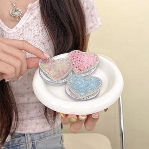 Dettaglio macro del Griptok a forma di cuore con strass e paillettes in tre colori