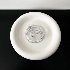 Detailed view of silver bow-knot charms in bear-shaped gift packaging for phone grip