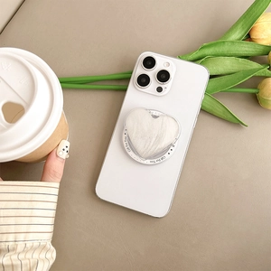 Close-up of heart-shaped white plush phone grip with Gift For You text on back of phone