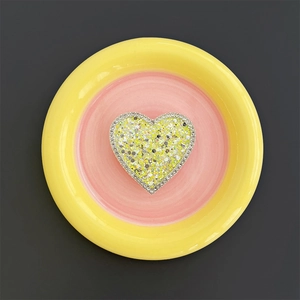 Macro detail of heart-shaped phone grip with yellow sequins and sparkling rhinestones