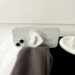 Vue détaillée du support de téléphone en forme de cœur blanc avec texture nacrée et métal