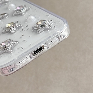 Detail of transparent iPhone case with silver star accents and holographic glitter flakes