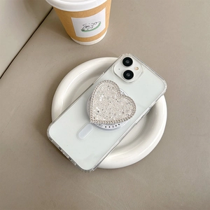 Dettaglio dell'impugnatura per telefono glitterata a cuore su custodia trasparente