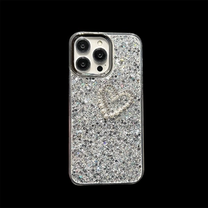 Macro detail of silver glitter iPhone case with pearl heart and sparkly bow decorations
