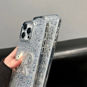Detailed view of handmade rhinestone bow and sparkling glitter on clear iPhone cases